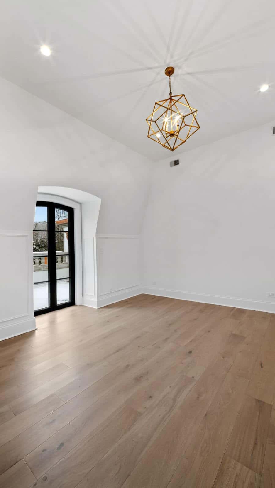 Light wood plank flooring in an empty, sunlit room