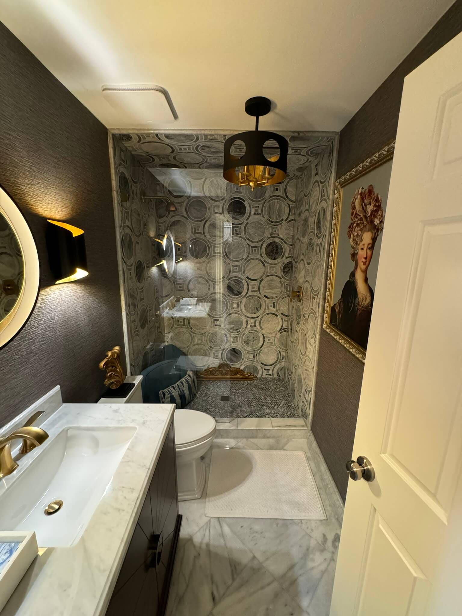 Bathroom remodel with a patterned tile shower and marble floor