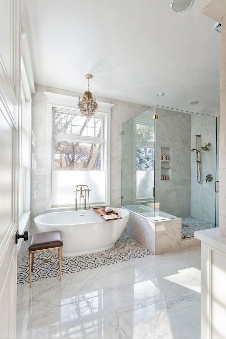 Freestanding tub, marble walls, and a glass shower in a bathroom remodel