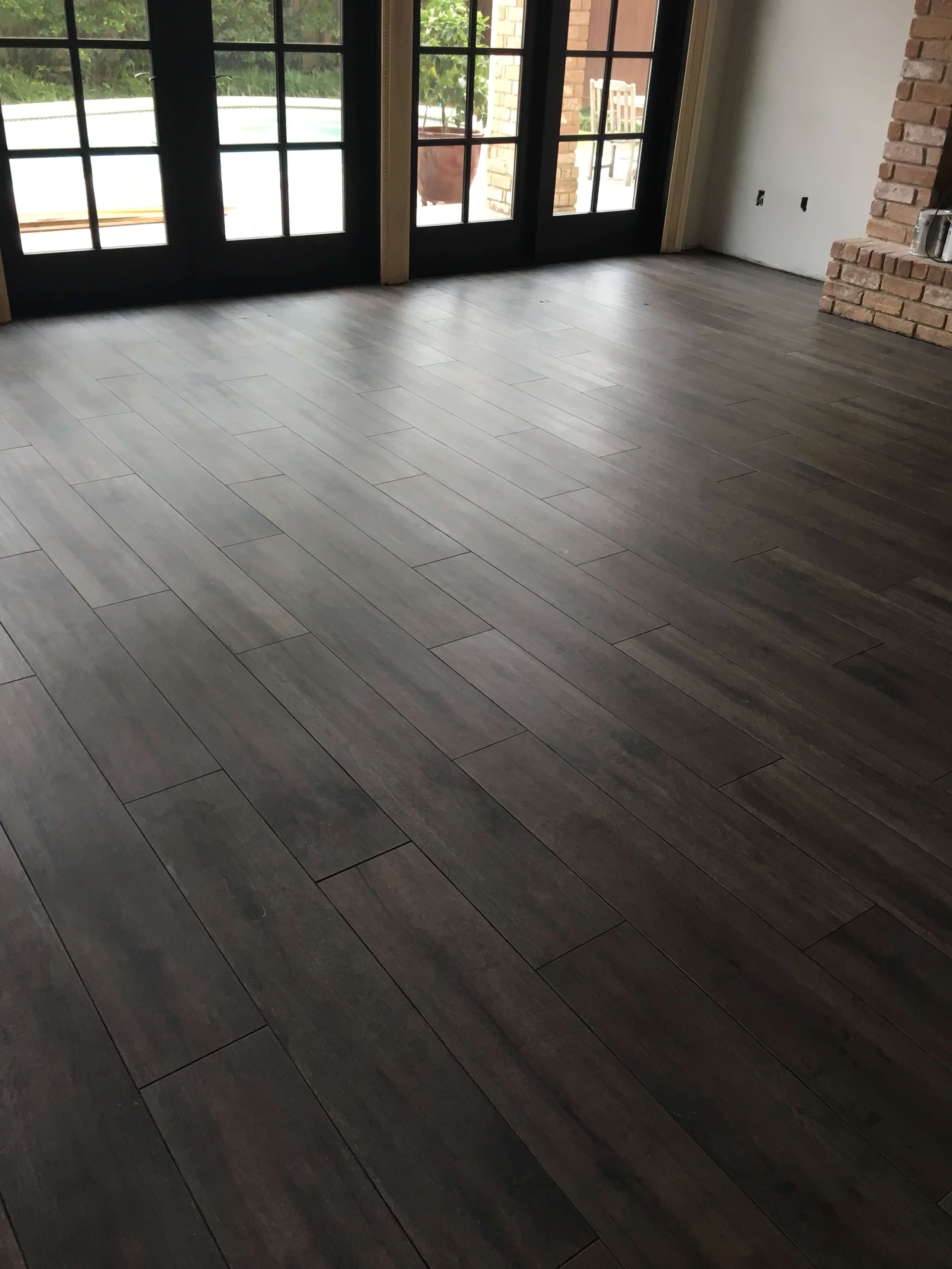 Dark wood-look plank floor running toward black-framed French doors
