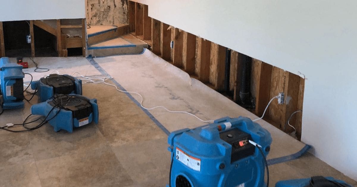 Air movers drying a room during water damage restoration